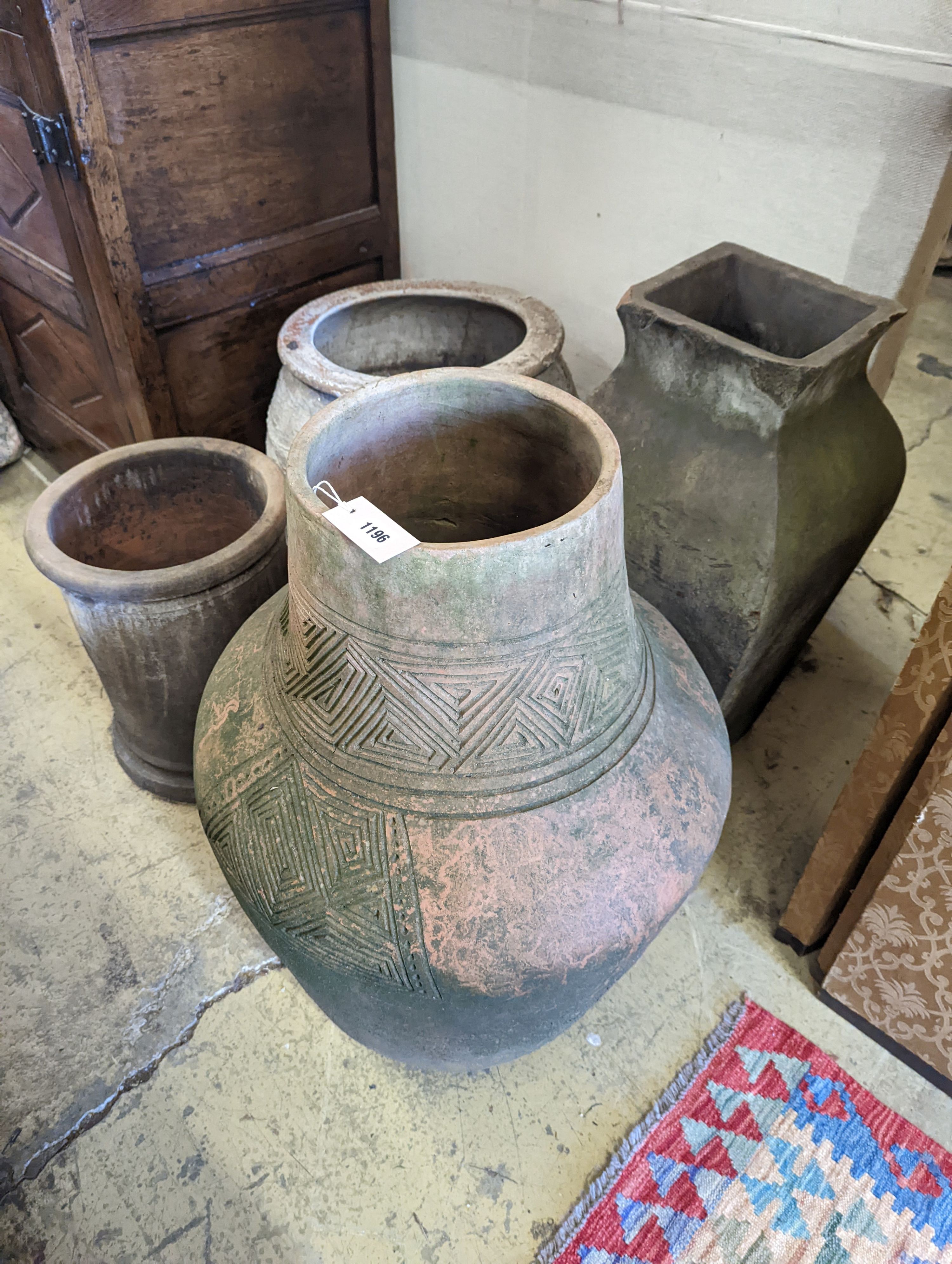 A large incised terracotta garden urn, height 72cm together with three other large earthenware garden urns